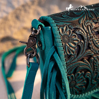 Close-up of a turquoise Montana West crossbody purse with intricate floral tooling and fringe details.