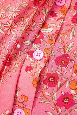Close-up of the Morning Glory Blouse, showing its vibrant floral geometric pattern and pink buttons.