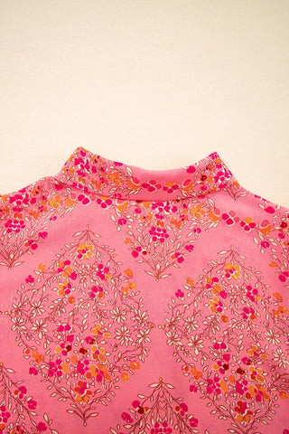 Close-up of the Morning Glory Blouse, showcasing its vibrant floral geometric pattern in pink, orange, and red.