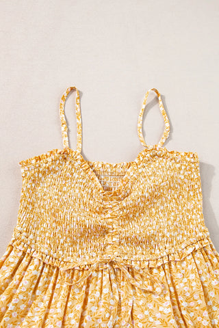 Close-up of a yellow floral maxi dress with a shirred bodice, adjustable tie front, and delicate straps.