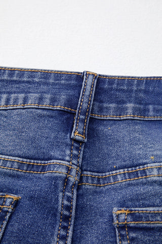 Close-up of the back waistband and belt loop of Open Sky Bootcut Jeans with orange stitching.
