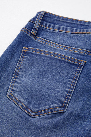 Close-up of the back pocket and waistband of Open Sky Bootcut Jeans, showing blue denim with orange stitching.