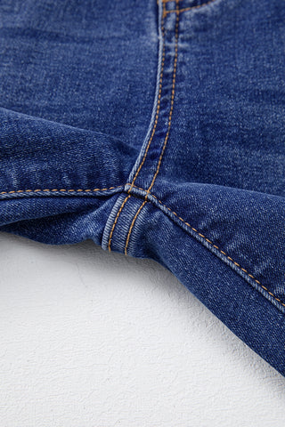 Close-up of the crotch area of dark wash Open Sky Bootcut Jeans with visible orange stitching.