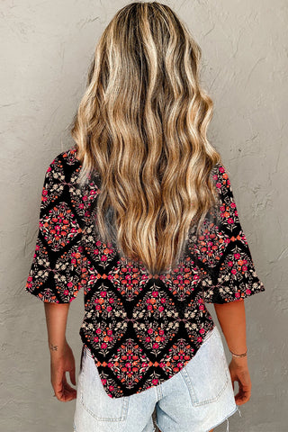 Back view of a woman wearing a black Porchlight Bloom Button Top with a vibrant floral lattice pattern.