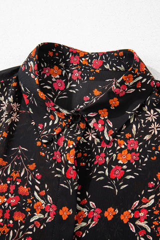 Close-up of a black Porchlight Bloom Button Top with a vibrant floral pattern in red, orange, and white.