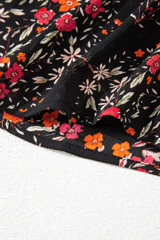 Close-up of the Porchlight Bloom Button Top, showcasing its black fabric with a vibrant floral lattice pattern.