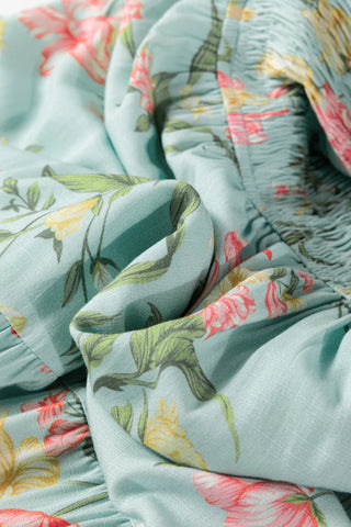 Close-up of the Prairie Bloom Smocked Dress, showing the light blue fabric with pink and yellow floral print.