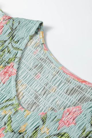 Close-up of the light blue Prairie Bloom Smocked Dress with pink floral print and smocked bodice detail.