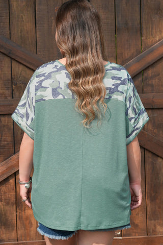 Back view of a woman wearing a Prairie Camo Dreams Top, a camo sage tee with a ribbed sage green body.