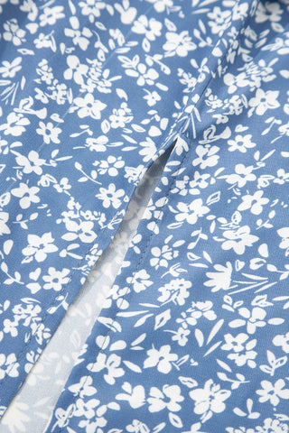 Close-up of a blue ditsy floral midi skirt with white flowers and a subtle slit.