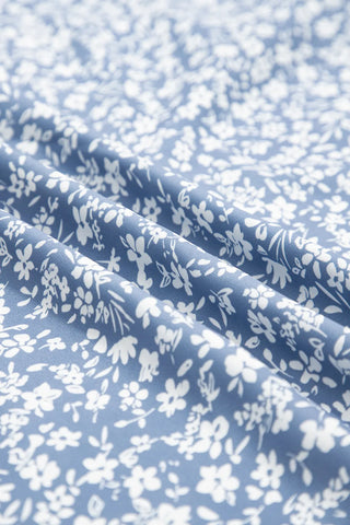 Close-up of the Prairie Ditsy Floral Skirt fabric, showing white ditsy floral print on a blue background.