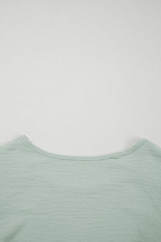 Close-up of the light green Prairie Ruffle Blouse, showing the boat neck and textured fabric.