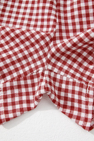 Close-up of red and white gingham shorts, showing fabric texture and stitching details at the crotch.