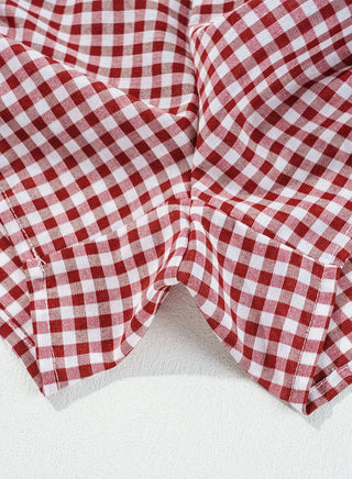 Close-up of red and white gingham shorts, showing fabric texture and stitching details.