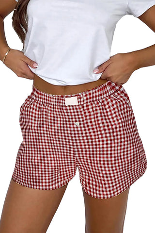 A person wearing red and white gingham shorts with an elastic waistband and a single white button.