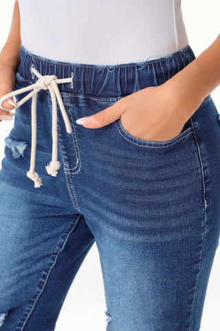 Close-up of Ranch Hand Distressed Jeans with an elastic waist, drawstring, and front pockets.