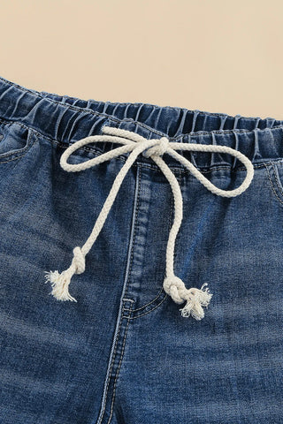 Close-up of Ranch Hand Distressed Jeans with an elastic waistband and white drawstring tie.