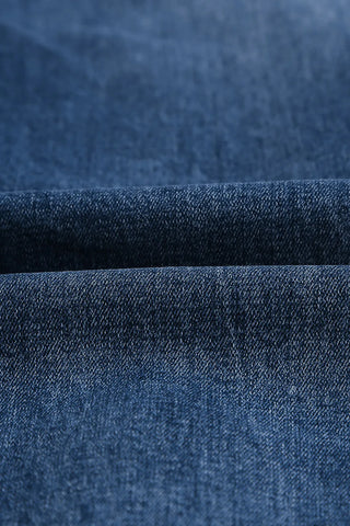Close-up of the dark blue denim fabric of the Ranch Hand Distressed Jeans, showing texture and subtle fading.