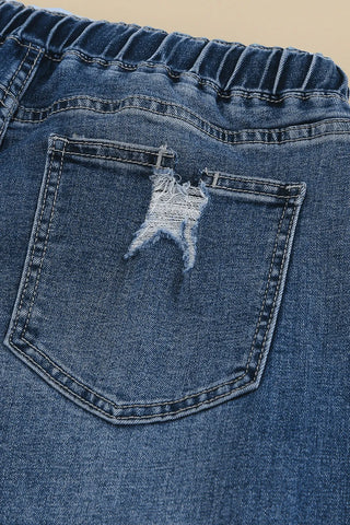Close-up of the back pocket of Ranch Hand Distressed Jeans, showing a distressed rip and elastic waistband.