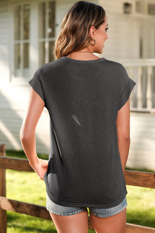 Woman from behind wearing a charcoal ribbed Saddle Breeze Top with cuffed sleeves and denim shorts.