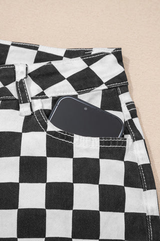 Close-up of black and white checkerboard distressed jeans with a phone in the front pocket.