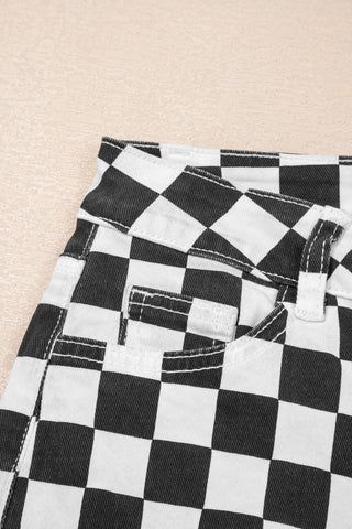 Close-up of the black and white checkerboard distressed jeans, showing the front pocket and belt loop.