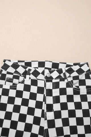 Close-up of the waist and upper legs of black and white checkerboard distressed jeans.