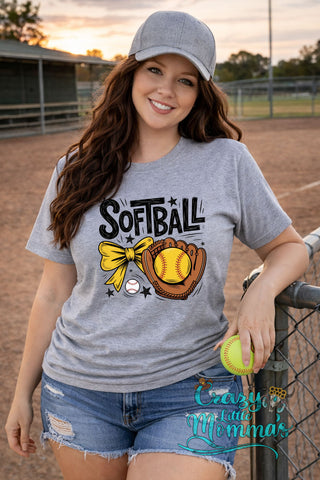 Woman in a gray softball tee with "SOFTBALL" text, a yellow bow, glove, and ball graphic.