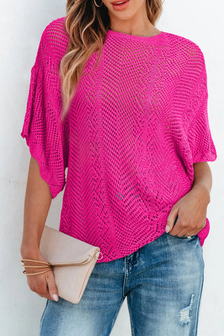 A woman models a vibrant pink Boho Chevron Knit Top with a loose weave, paired with distressed jeans.
