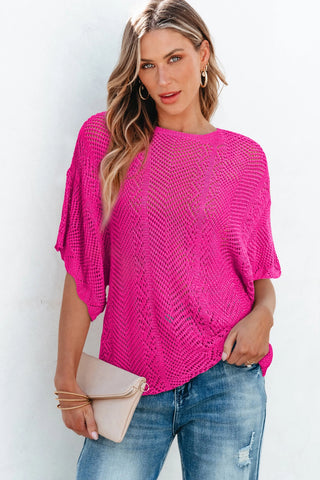 Woman in a bright pink Boho Chevron Knit Top with short sleeves and a textured pattern, paired with distressed jeans.
