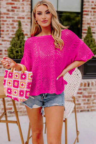 A woman models a bright pink Boho Chevron Knit Top with a loose fit and short sleeves, paired with denim shorts.