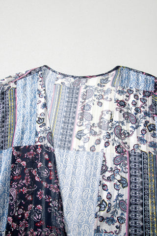Close-up of a sheer Wanderlust Patchwork Kimono with various blue, white, and pink paisley and floral patterns.