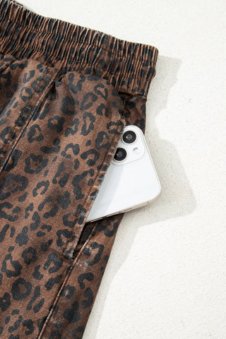Close-up of a Wildcat Drawstring Skort pocket with a white smartphone tucked inside, showcasing the leopard print.