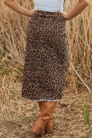 A woman from the waist down wearing a Wildcat Midi Denim Skirt with a leopard print and brown boots.