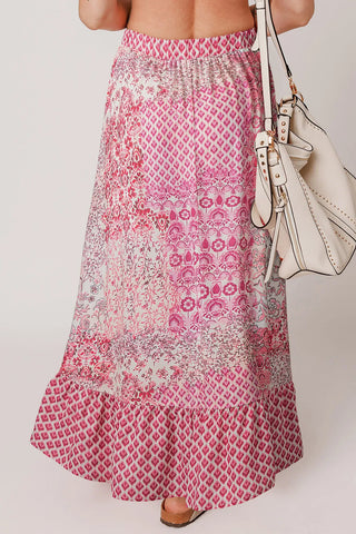 Back view of a woman wearing a pink Wildflower Patchwork Maxi Skirt with a white handbag.