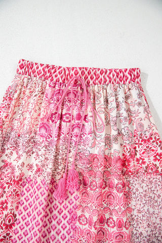 Close-up of a Wildflower Patchwork Maxi Skirt with an elastic waist and pink tassel drawstring.