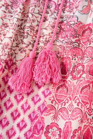 Close-up of a Wildflower Patchwork Maxi Skirt with pink tassels and various floral and geometric patterns.