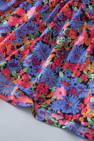 Close-up of the Wildflower Ruffle Babydoll Top, showing its vibrant floral pattern and ruffled hem.
