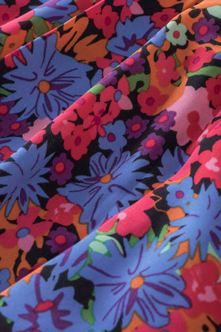 Close-up of the Wildflower Ruffle Babydoll Top, showing its vibrant floral print with blue, pink, and orange flowers.