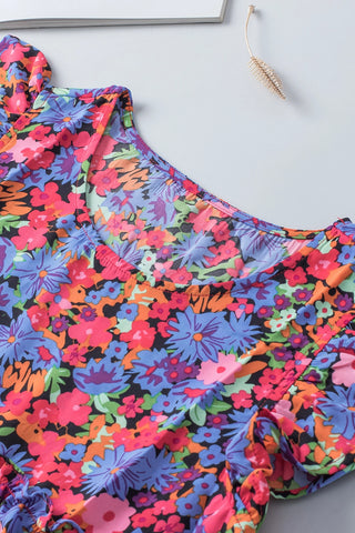 Close-up of a vibrant floral babydoll ruffle top with a colorful wildflower print and ruffled details.