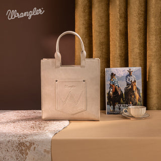 Beige Wrangler tote bag with an embroidered Aztec design and matching wallet, displayed on a western-themed set.