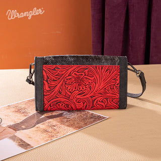 Wrangler red and black hair-on cowhide tote/crossbody with embossed floral design, on a table with a photo.