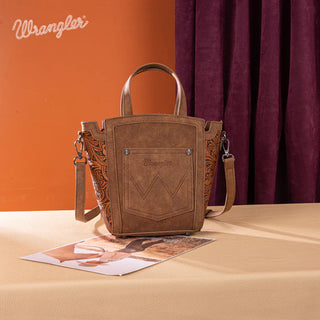 Brown Wrangler tote/crossbody with a front pocket, embossed sides, and a removable strap on a table.
