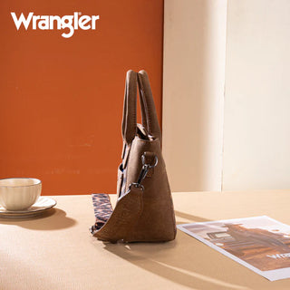 Brown Wrangler crossbody bag with leopard print strap and card case, shown on a table with a cup and magazine.