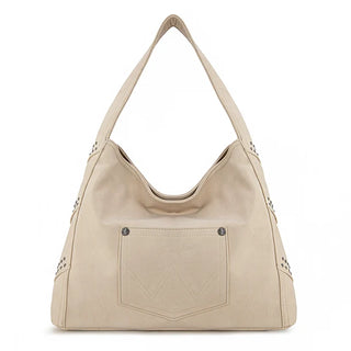 Beige Wrangler hobo bag with studded details, fringe, and a front pocket with the Wrangler "W" stitching.
