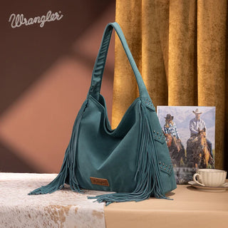 Turquoise Wrangler hobo bag with studded details and long fringe, displayed on a patterned surface.