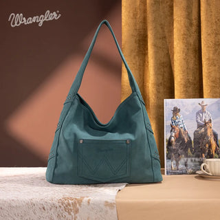 Turquoise Wrangler hobo bag with studded details and a front pocket, on a cowhide rug.