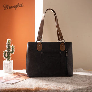Black Wrangler Whipstitch Tote Bag with brown handles, front pocket, and side zipper, on a cowhide rug.
