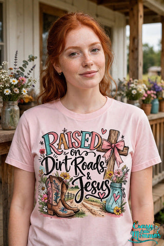 Dirt Roads and Jesus graphic tee on a light pink shirt